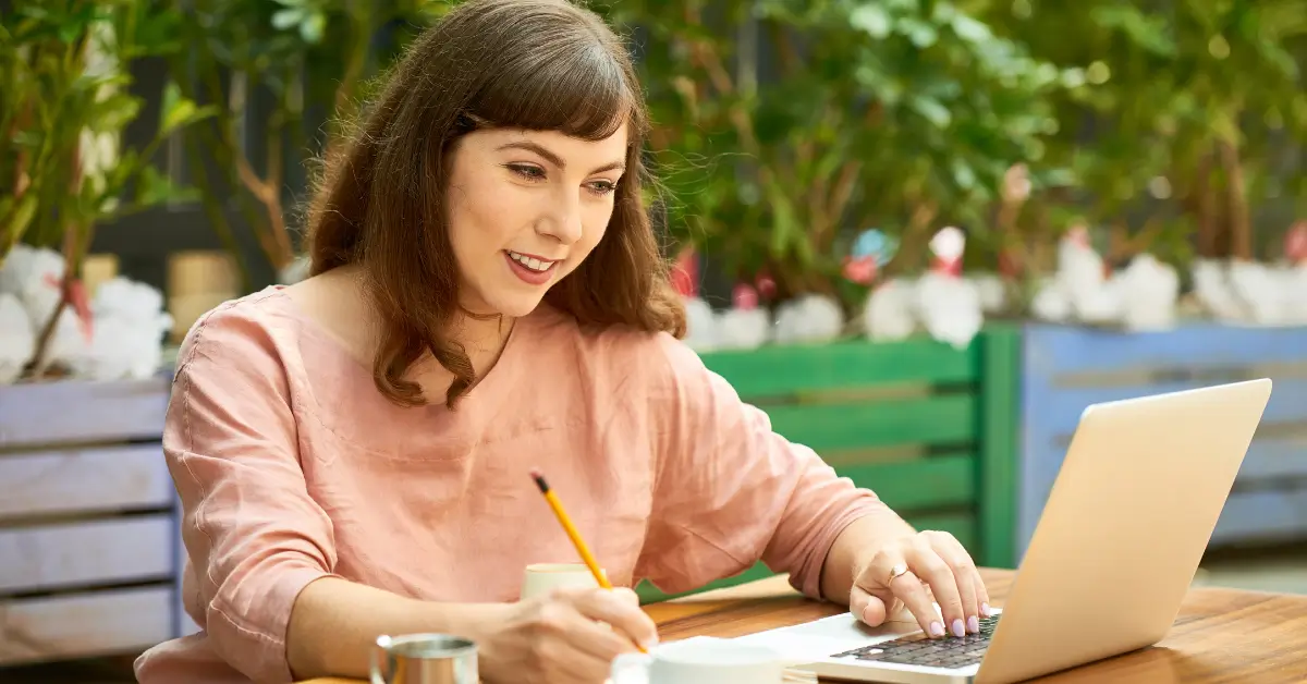 Confident woman in her 40s working remotely from home on a new career path with laptop and coffee